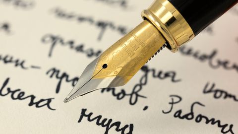 Close-up of a fountain pen nib on handwritten paper