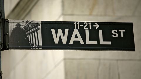 A Wall St street sign on the corner of a stone building
