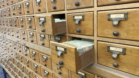 Rows of wooden library card-catalogue drawers, one pulled open