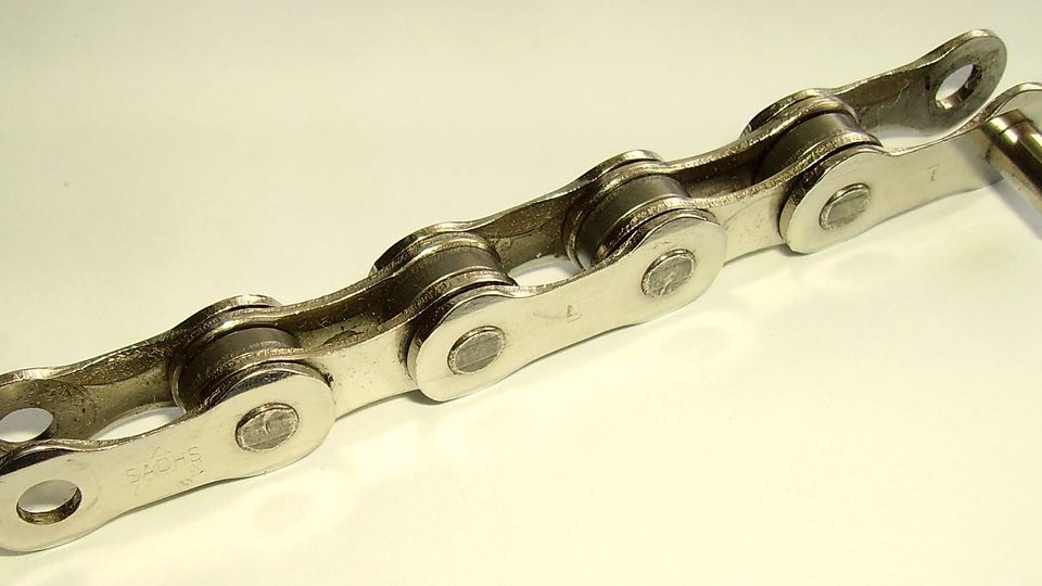A short length of bicycle chain on a white background