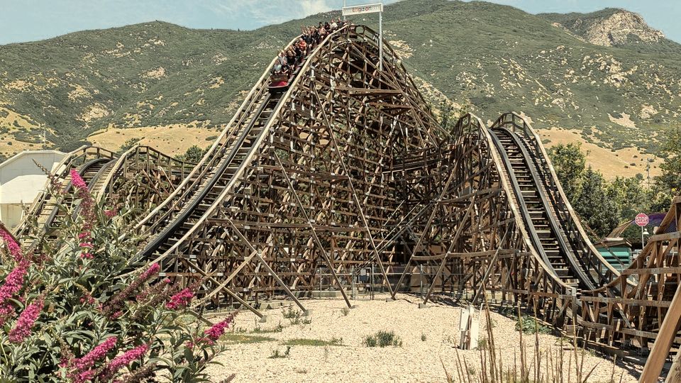 A wooden roller coaster with steep rises and drops